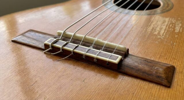 弦がギターにテンションをかけている画像